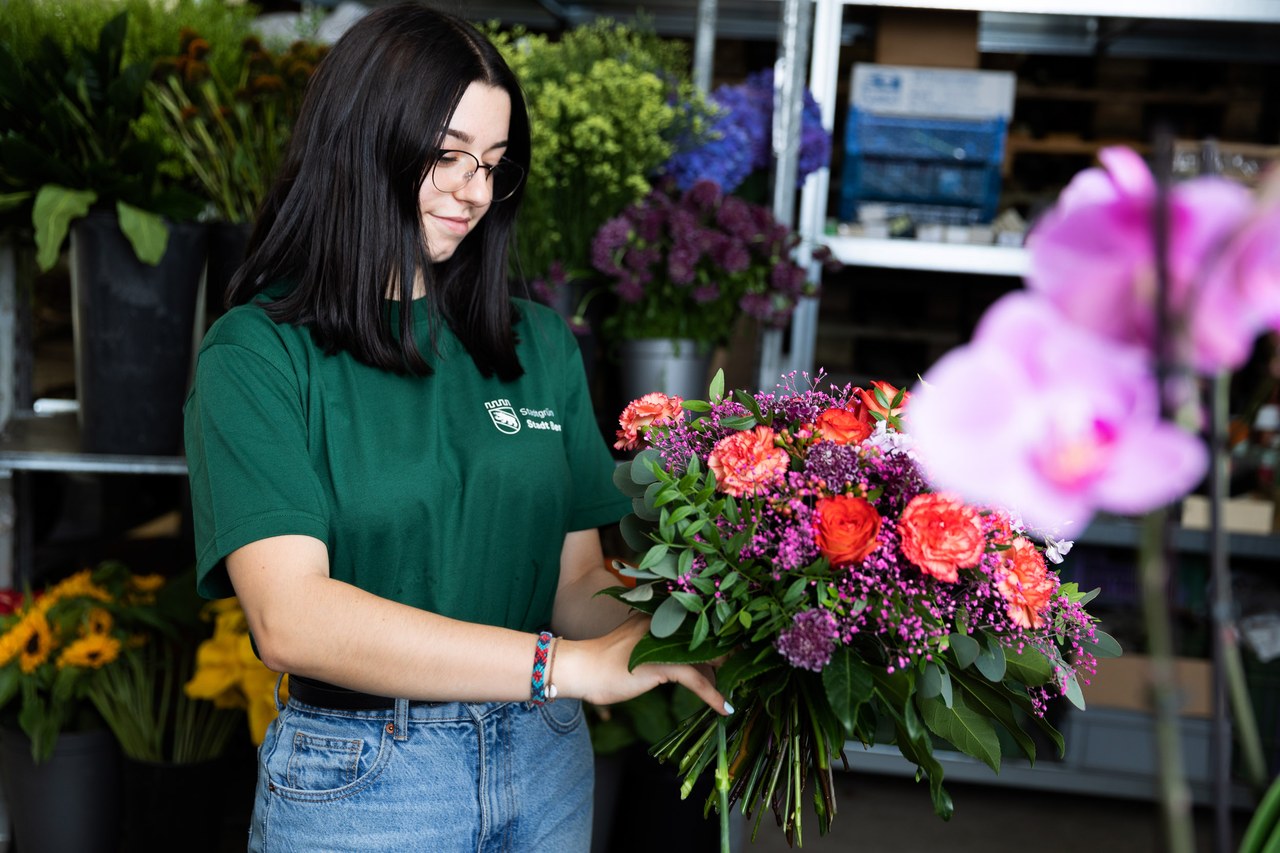 Floristin beim Schmücken eines Blumenstrausses