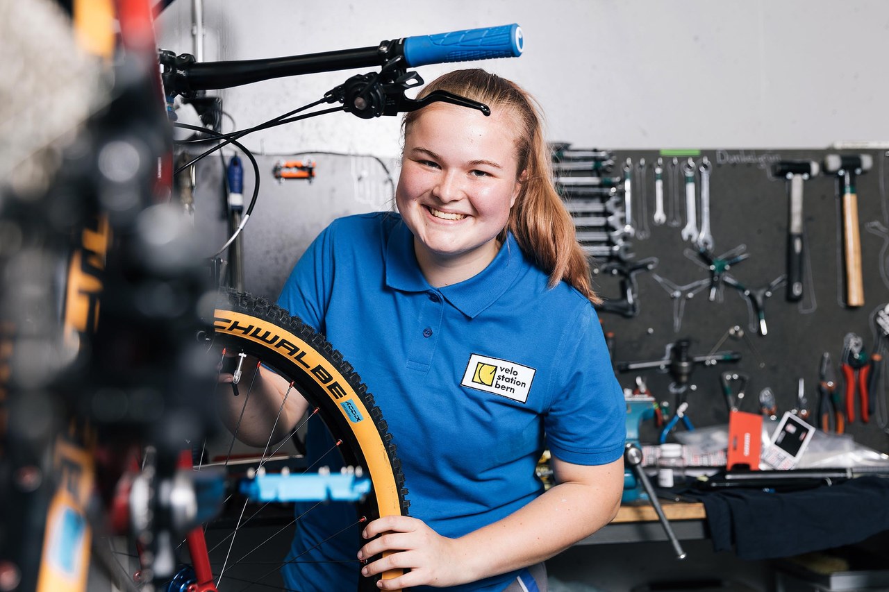 Fahrradmechanikerin beim Kontrollieren eines Rades