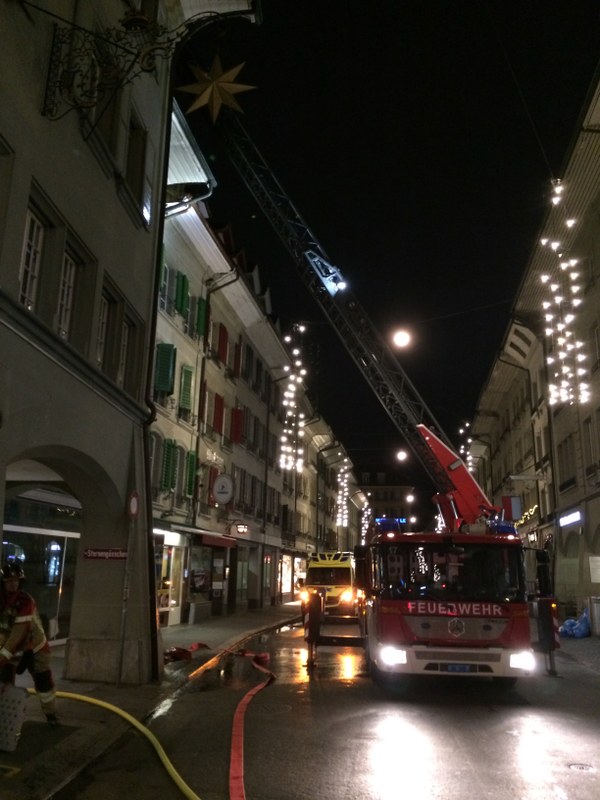 Autodrehleiter der Berufsfeuerwehr stationiert in der Aarbergergasse, bereit, um den Brand über das Dach der Liegenschaft im Sternengässchen zu bekämpfen.