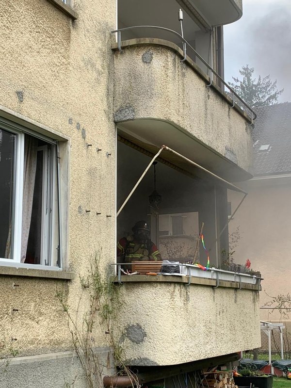 Feuerwehrmann mit Atemschutz auf dem Balkon der betroffenen Wohnung.