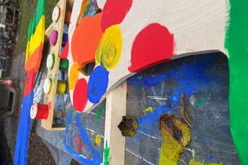 3 Eine Holzfigur, teilweise bemalt mit verschiedenen Farben. Vergrösserte Ansicht