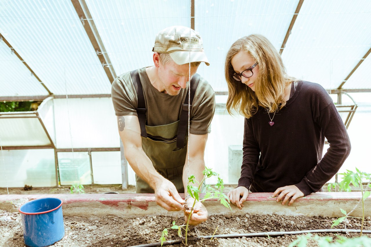 Jugendliche mit Fachleiter bei Gartenarbeit