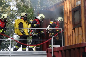 Angehörige der Feuerwehr während Übung auf der Heissausbildungsanlage Bern. Vergrösserte Ansicht