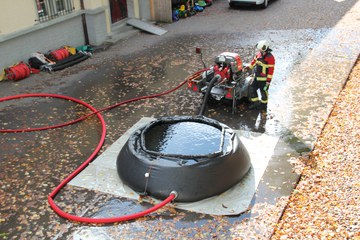 Bedienen der Motorspritze neben Ausgleichsbecken. Vergrösserte Ansicht