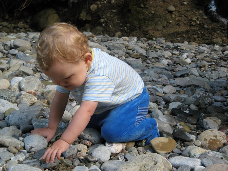 Kind spielt mit Flusssteinen