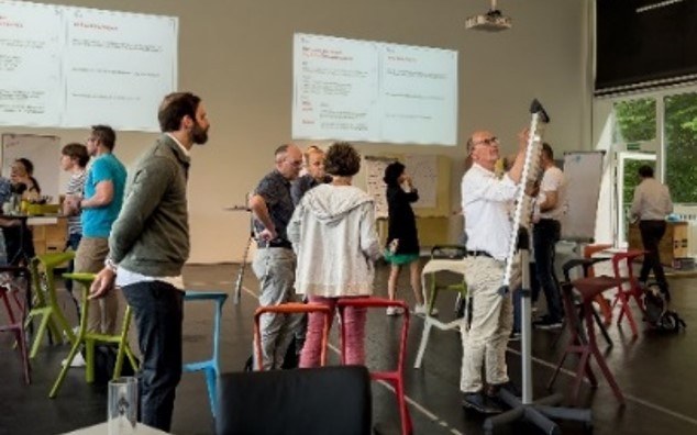 Workshop: Teilnehmende diskutieren und notieren Ideen auf Whiteboards
