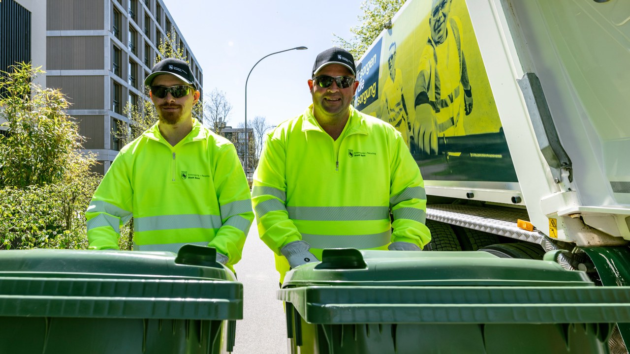 zwei Mitarbeiter von ERB mit Grüngut-Containern