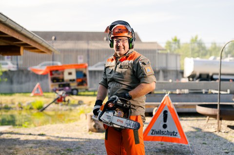 Zivilschutz-Mitarbeiter mit Motorsäge im Einsatz.