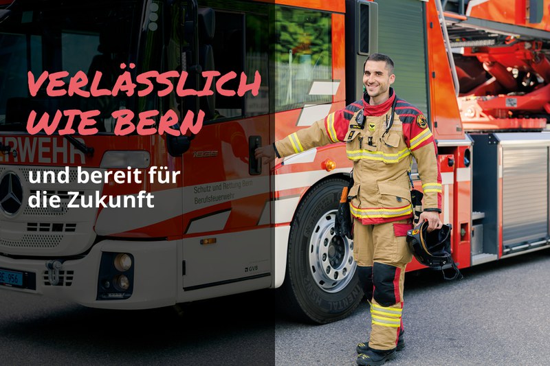 Feuerwehrmann in Einsatzkleidung steht lächelnd vor einem Feuerwehrauto. Text im Bild: „Verlässlich wie Bern – und bereit für die Zukunft“.