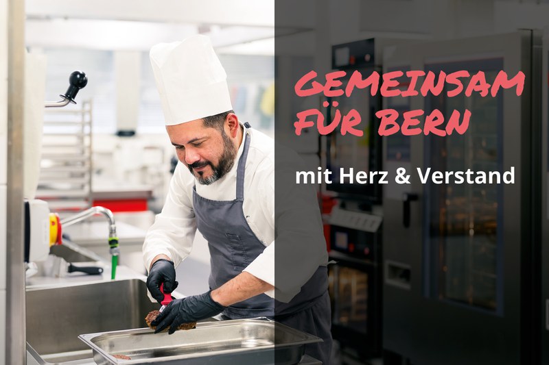 Koch bereitet Essen in einer Grossküche zu. Text im Bild: „Gemeinsam für Bern – mit Herz & Verstand“.