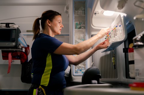 Sanitäterin ordnet medizinische Ampullen in einem Einsatzfahrzeug.