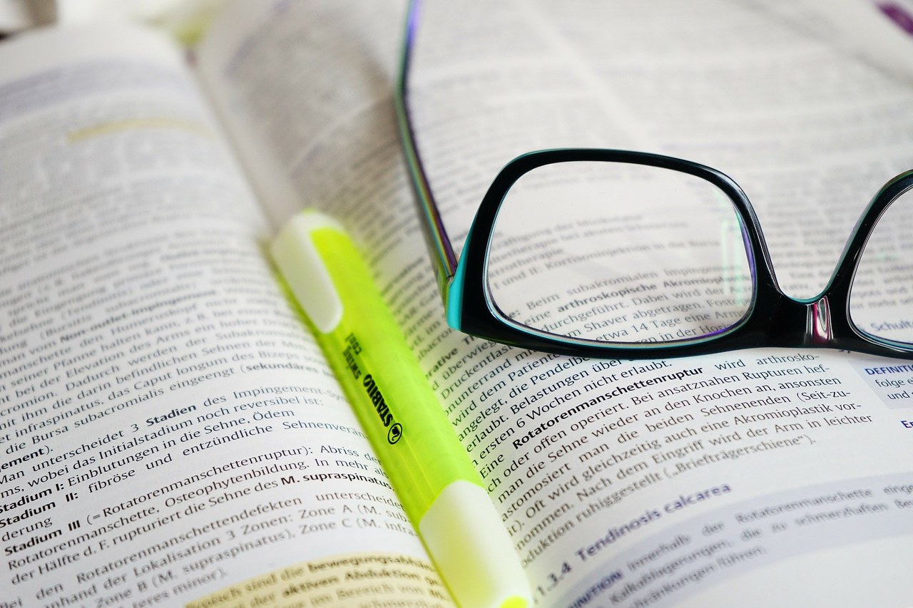 Symbolbild Vertiefungsmodule: Marker und Brille auf einem Buch