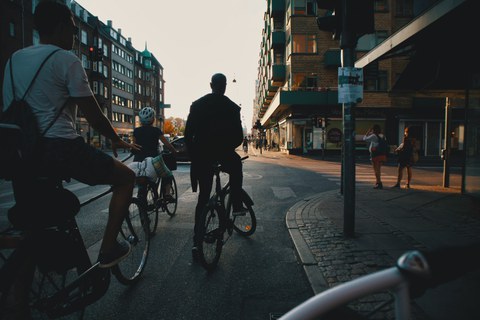 Symbolbild Mobilität: Velofahrer*innen warten bei einer roten Ampel