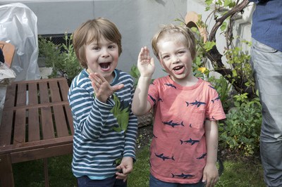 Zwei Kinder winken in die Kamera
