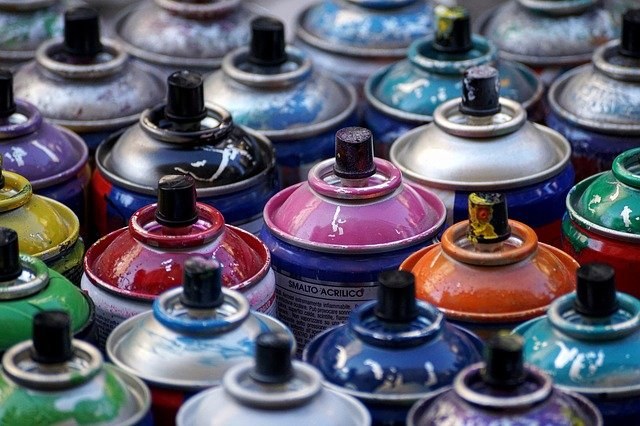 Köpfe von verschiedenen Spraydosen in zahlreichen Farben