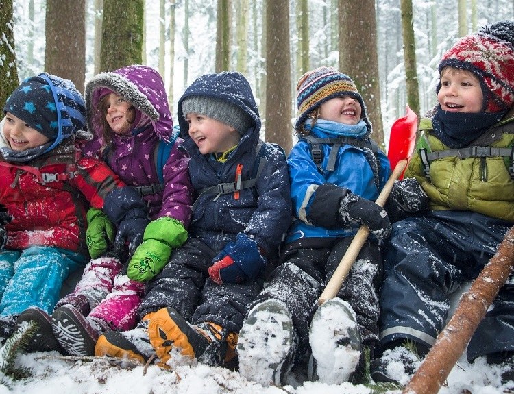 Lachende Kita-Kinder im Winterwald