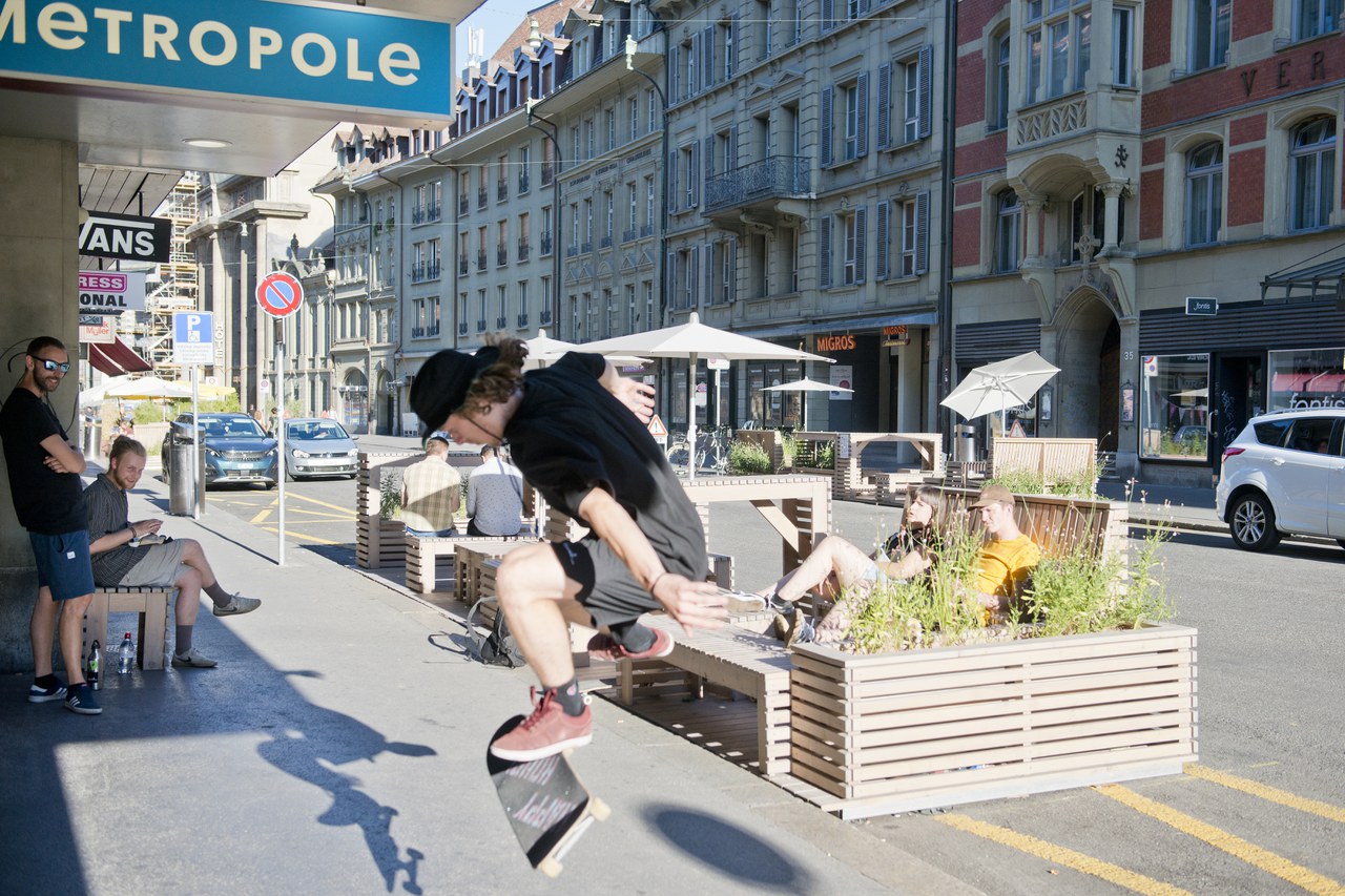 Ein Skateboarder führt in der Zeughausgasse einen Trick vor, dahinter sieht man die aus Holz gemachten Parklets